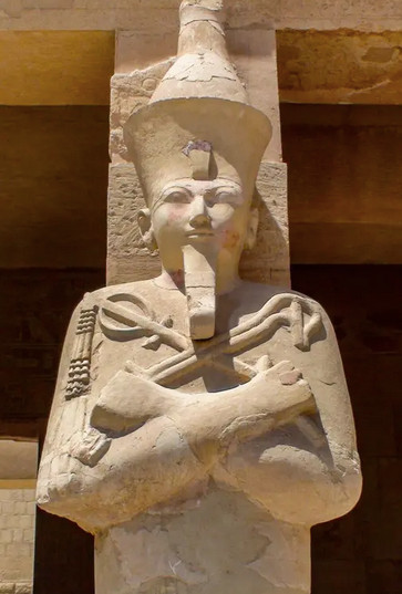 Egyptisk statue med krydsede arme og stave.